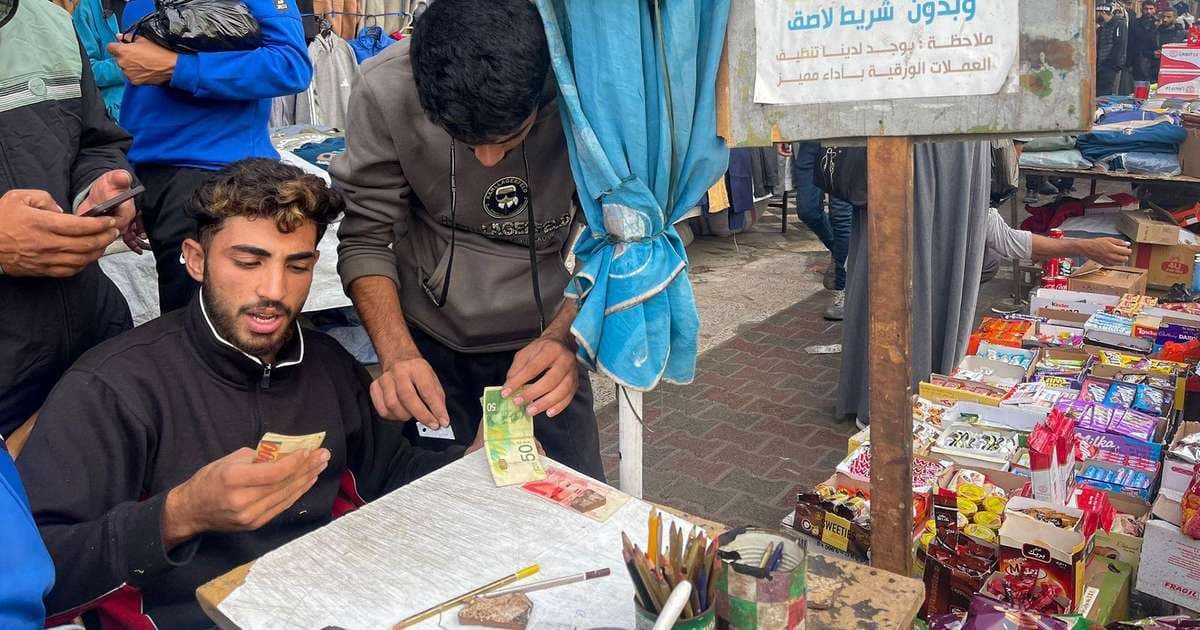 Jovem conserta dinheiro nas ruas de Gaza após devastação